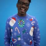a man in blue ugly christmas sweater singing
