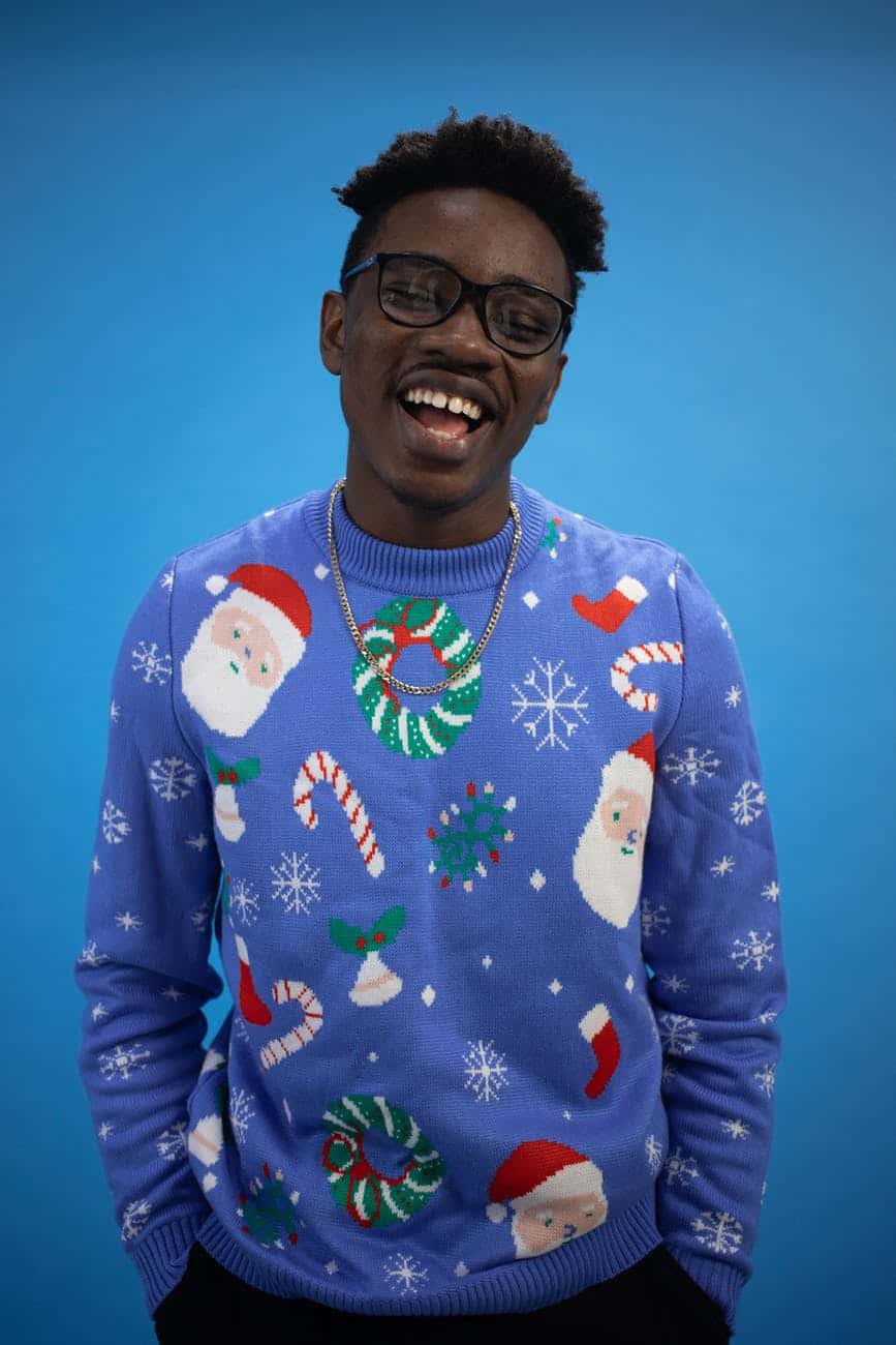 a man in blue ugly christmas sweater singing