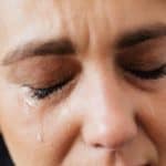 tears on face of crop anonymous woman