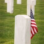 flag of u s a standing near a tombstone