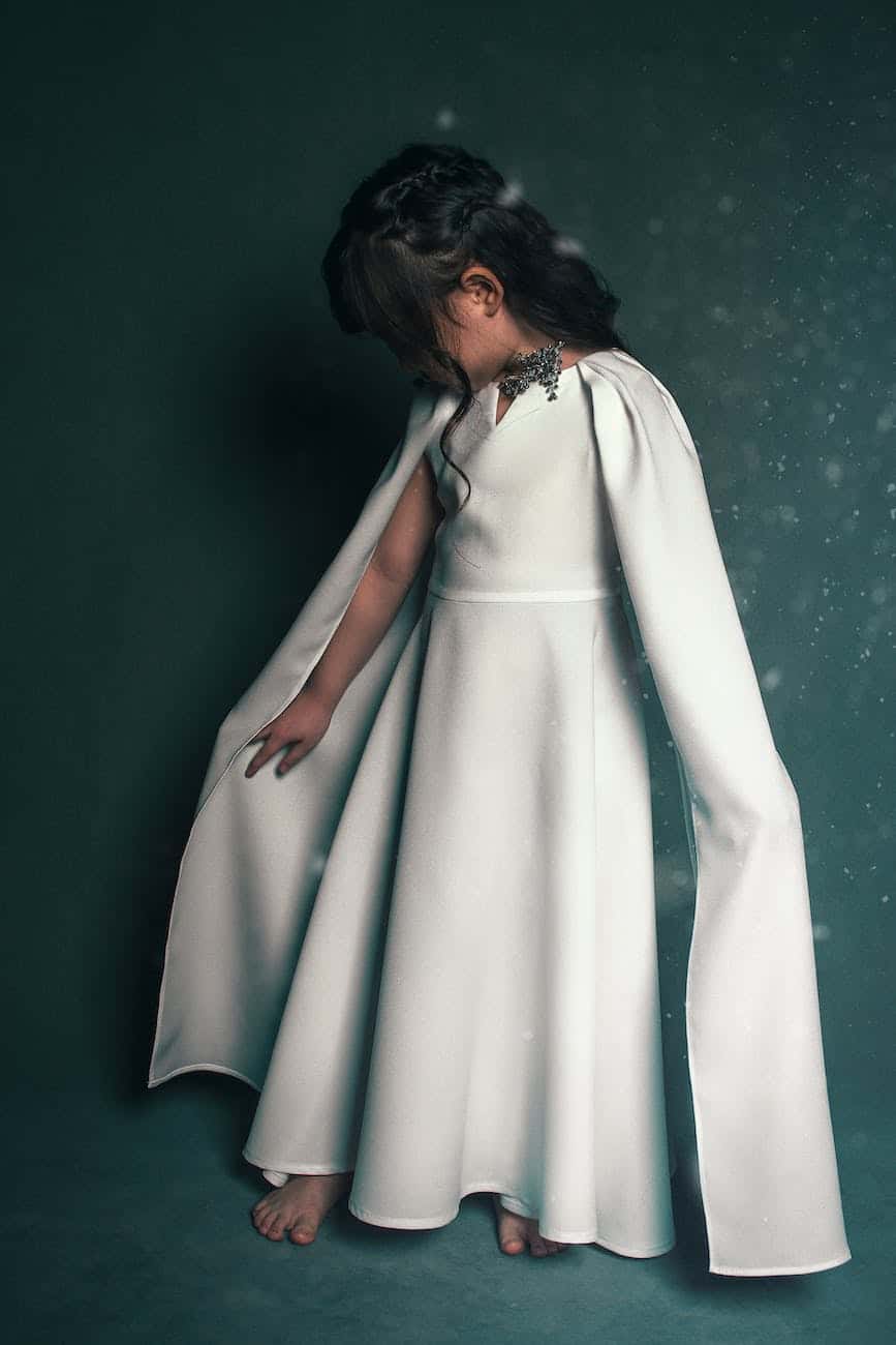 beautiful little kid in white dress with cape