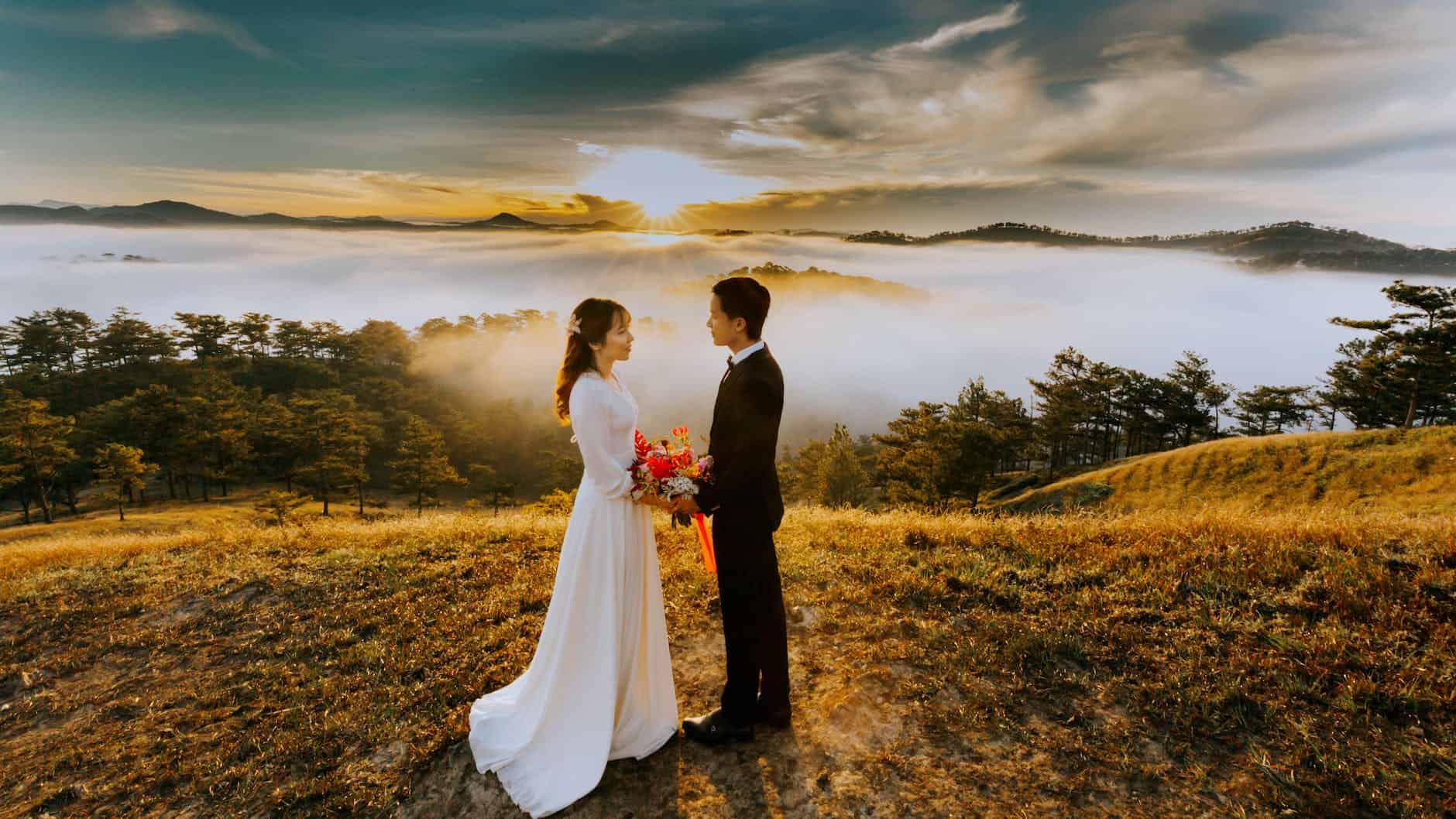 couple standing on grass field while looking at each other