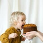 photo of a child eating a cake